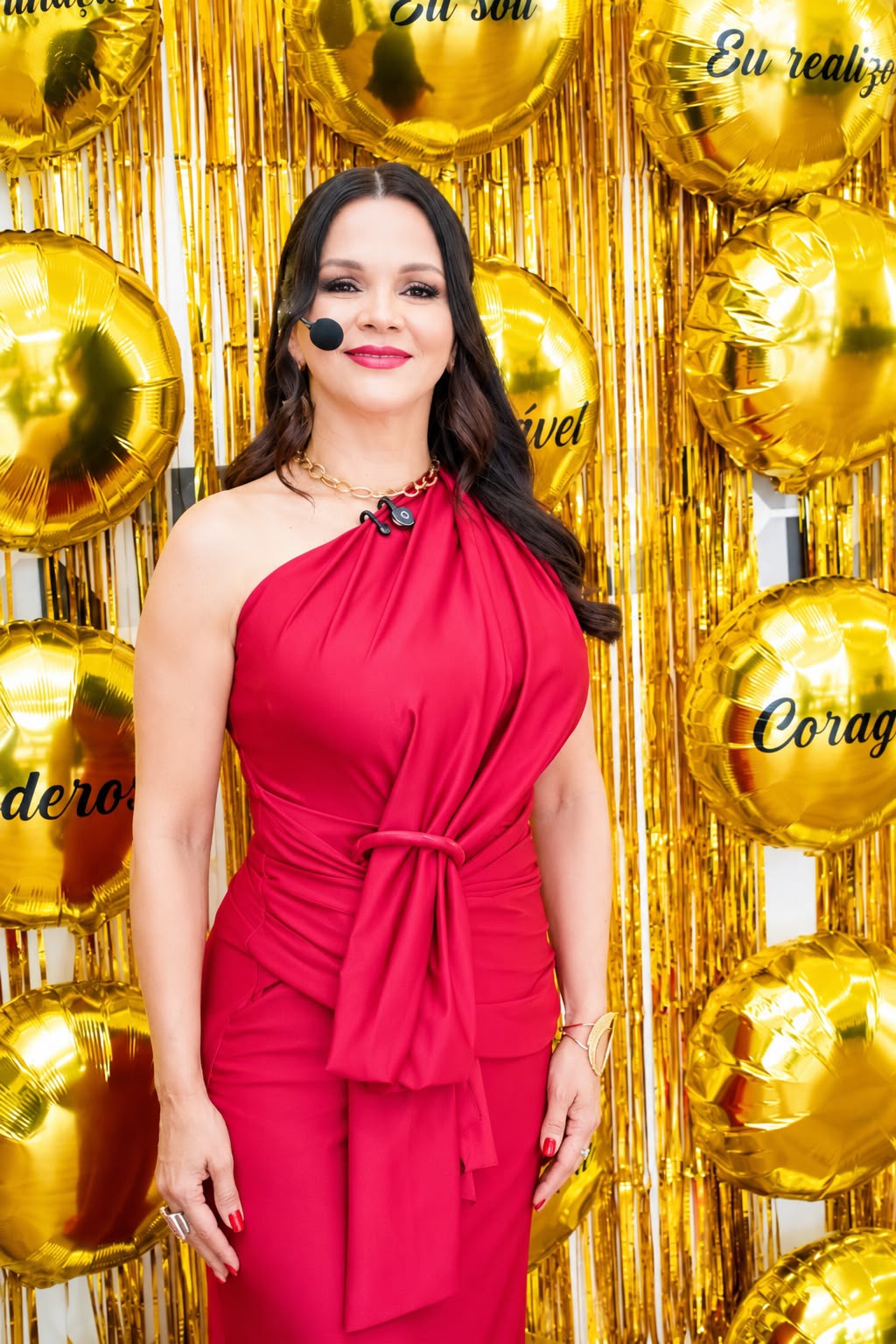 Andreia em evento, usando vestido vermelho
